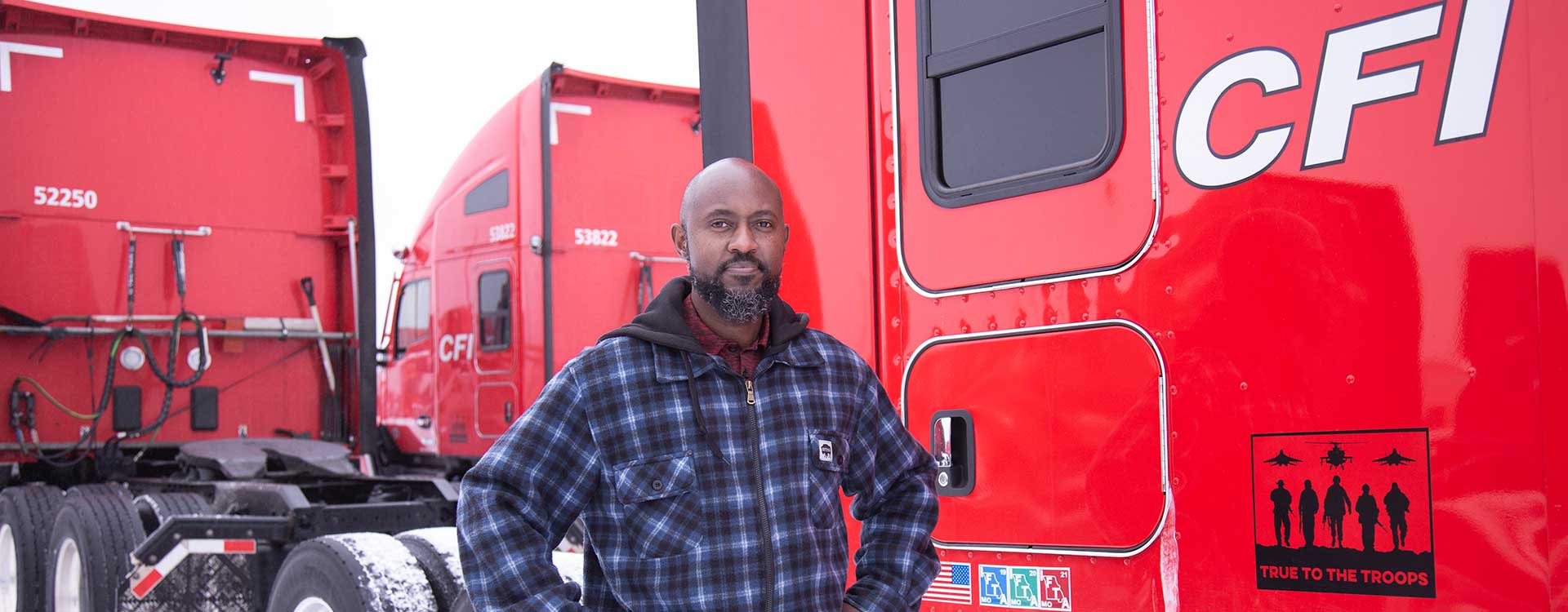 Man in front of red CFI trucks