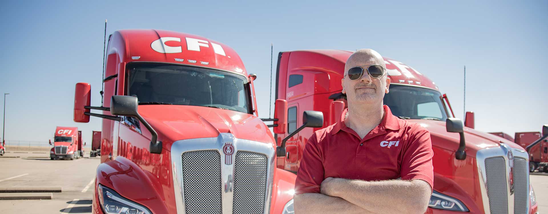 Man in CFI shirt in front of red CFI trucks
